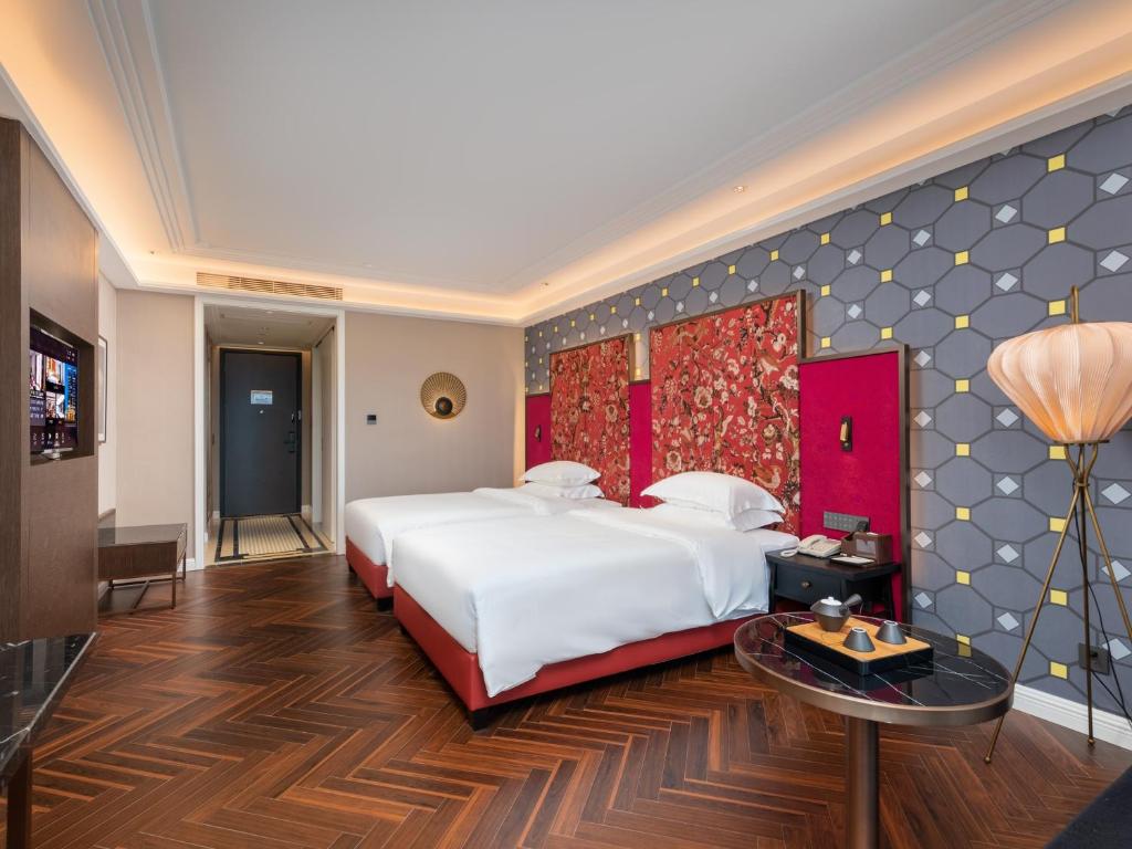 Postel nebo postele na pokoji v ubytování Shenzhen Longgang Central City Jinjiang Metropolo Hotel