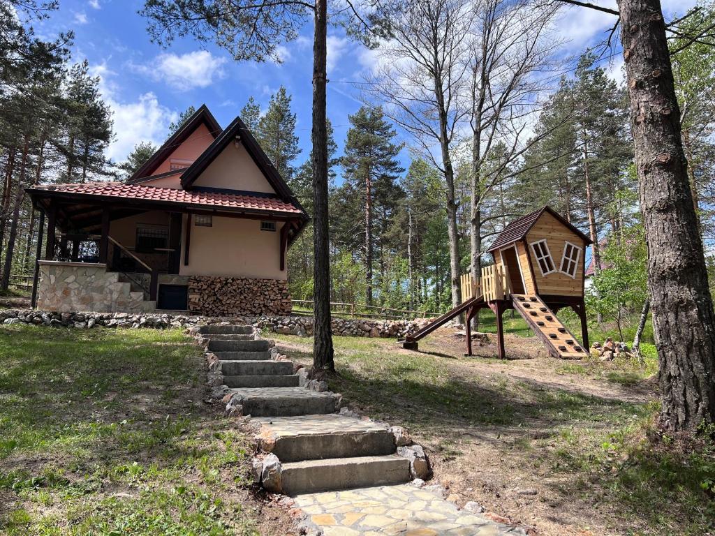 ein kleines Haus mit Rutsche und Spielplatz in der Unterkunft Vikendica Martinović in Divčibare