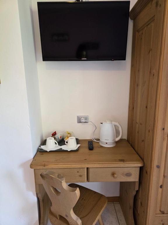 a wooden desk with a television on a wall at Antico Fienile Agritur in Mezzocorona