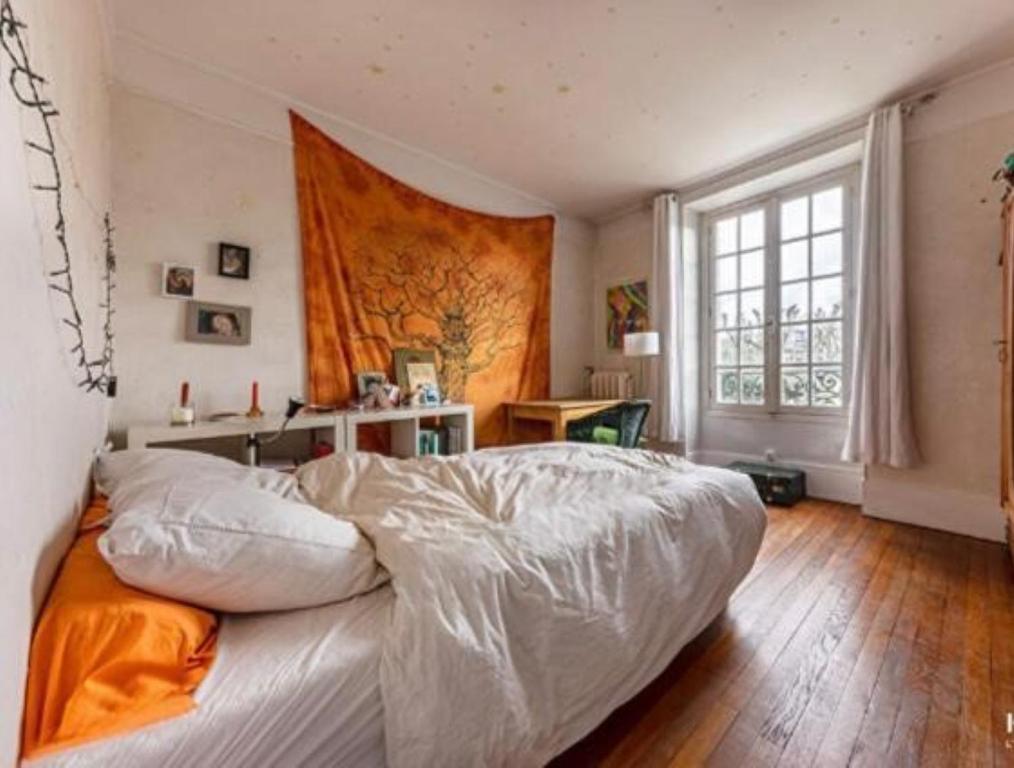 ein Schlafzimmer mit einem großen Bett und einem großen Fenster in der Unterkunft Quai Sisley in Villeneuve-la-Garenne