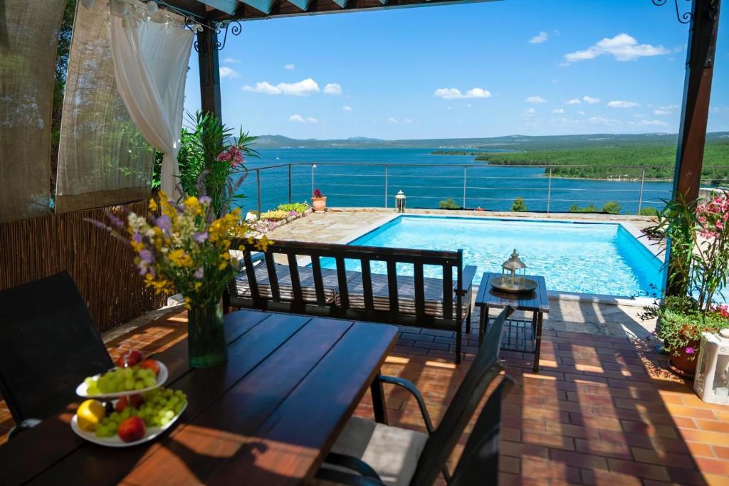 patio con tavolo e piscina di Holiday home Parma a Šibenik