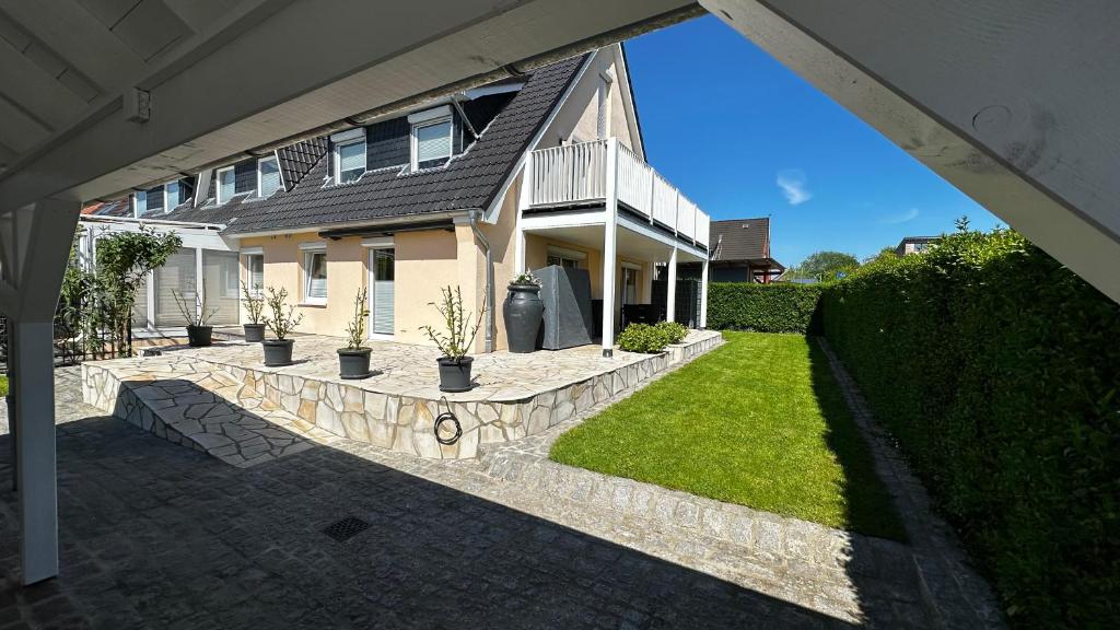a house with a stone walkway in front of a yard at SONNENSEITE 2 in Laboe