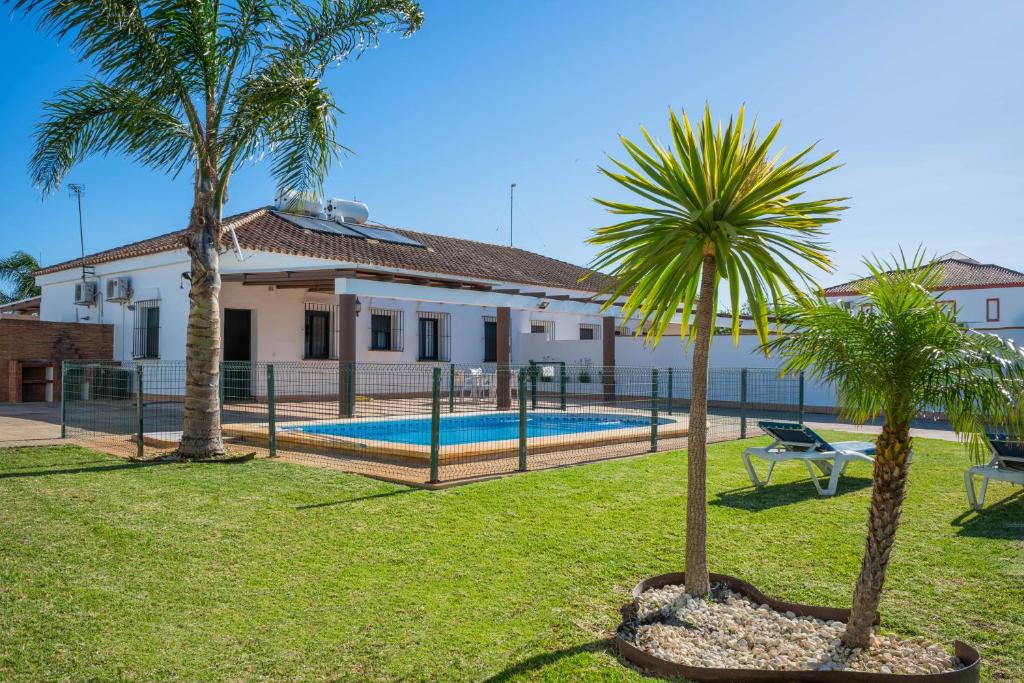 dom z dwoma palmami i basenem w obiekcie Casas Rurales Pericón w mieście Conil de la Frontera