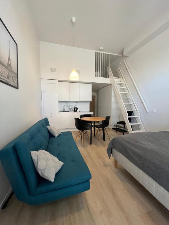 uma sala de estar com um sofá azul e uma mesa em Scandinavian loft 1BR apartment near city centre em Turku