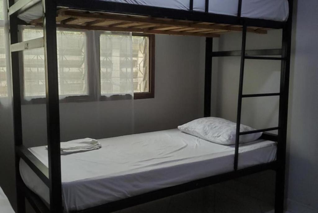 a bedroom with two bunk beds and a window at The Nest Haven Hostel in Dar es Salaam