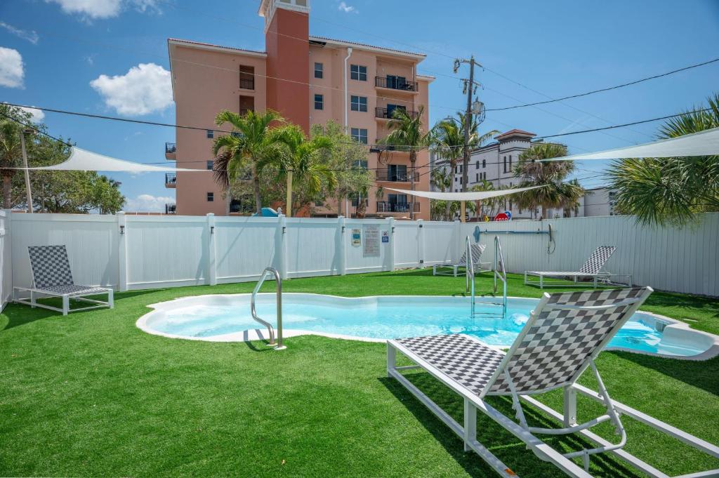 un patio trasero con una piscina con 2 sillas y un columpio en C2-Seahorse en St Pete Beach