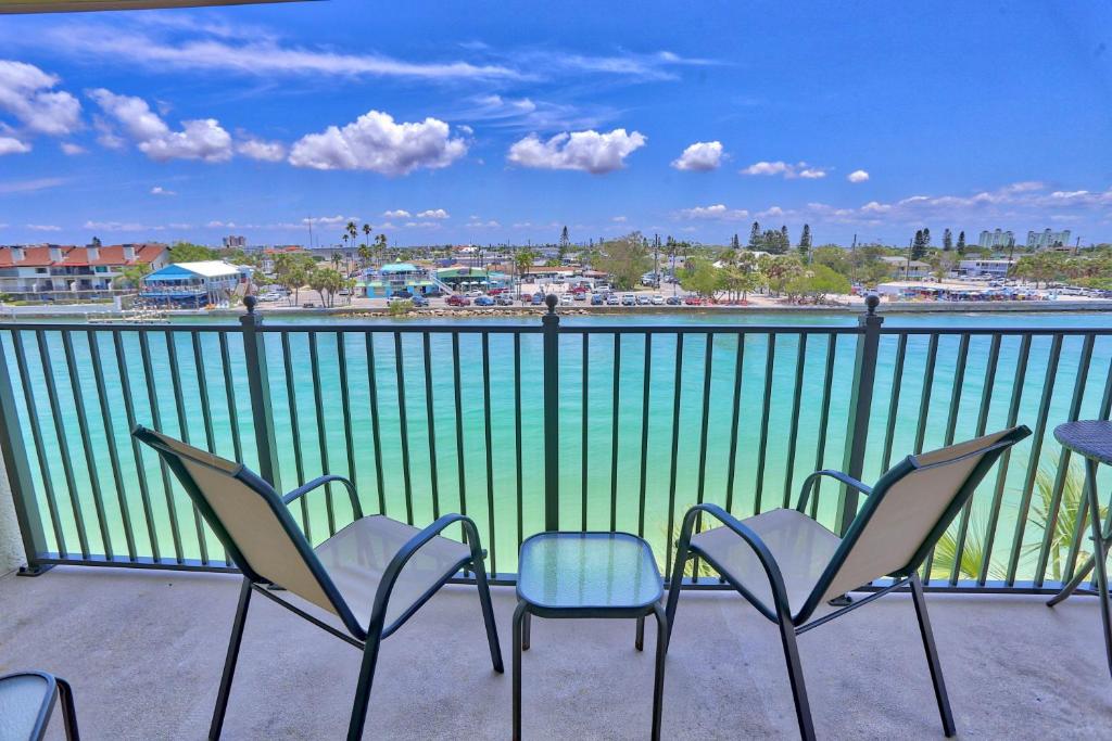 een balkon met stoelen en uitzicht op het water bij Land's End 4-406 Bay Front in St Pete Beach