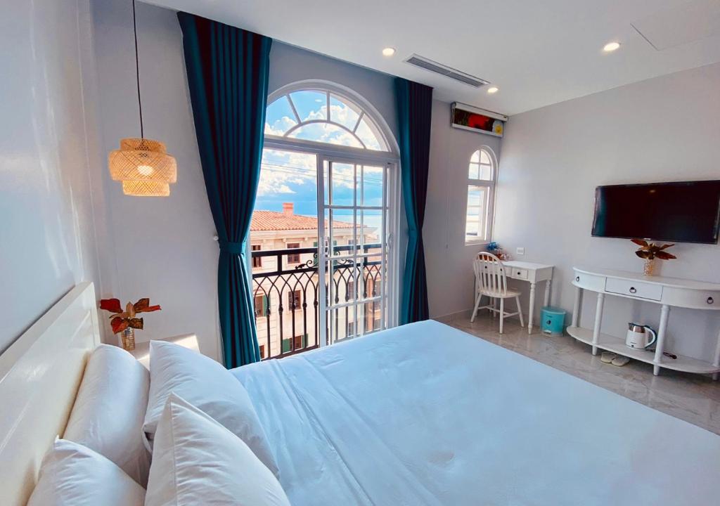 een slaapkamer met een groot bed en een groot raam bij Moonlight Hotel Phu Quoc in Phu Quoc