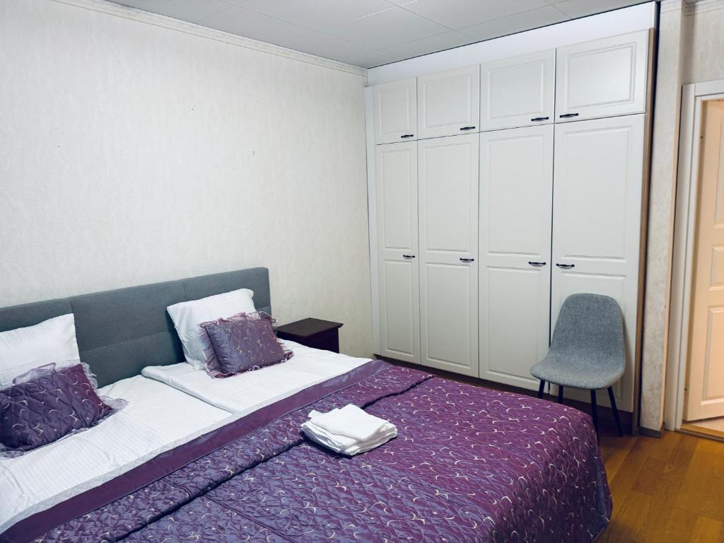 - une chambre avec un lit violet et une chaise dans l'établissement Real deal apartments Tampere, à Tampere