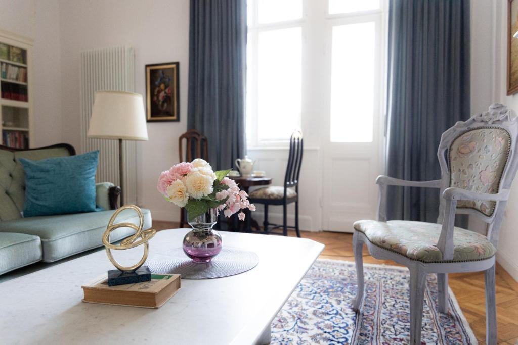 a living room with a vase of flowers on a coffee table at LittleParis in Cluj-Napoca