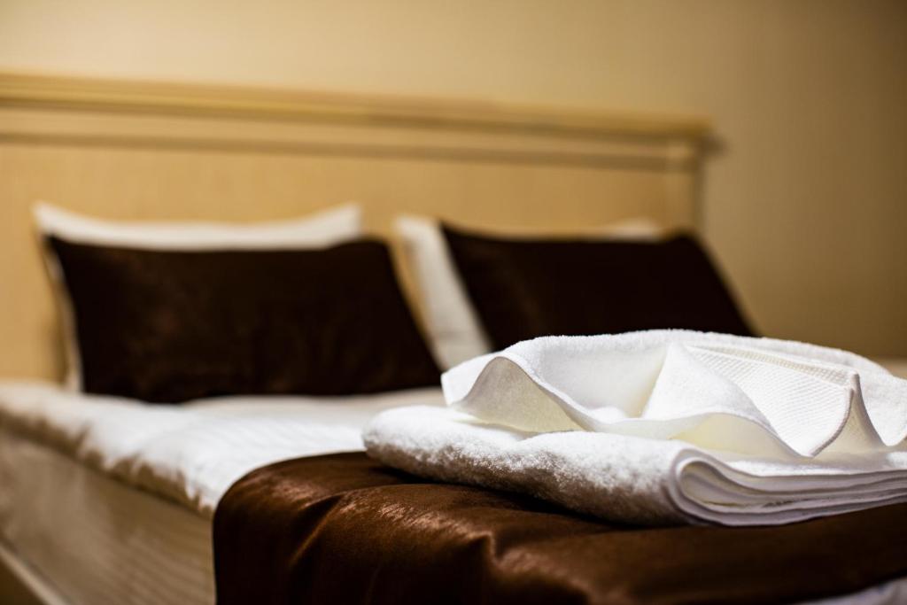 a bed with white towels sitting on top of it at SULO Atyrau Hotel in Atyraū