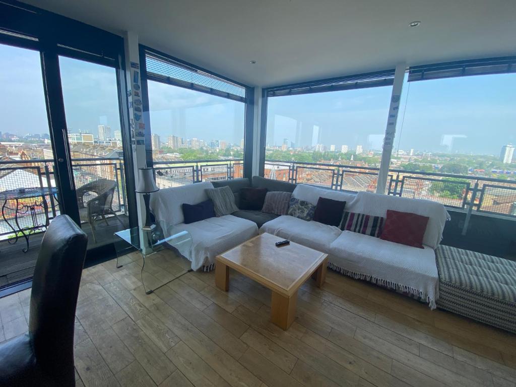 ロンドンにあるPenthouse in Battersea amazing views of Londonのリビングルーム(ソファ、テーブル付)