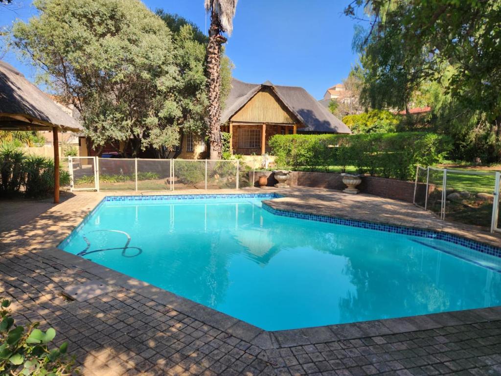 a swimming pool in a yard with a house at Valley Inn Guest House, Accommodation 6, Drakenstein Avenue in Sandown