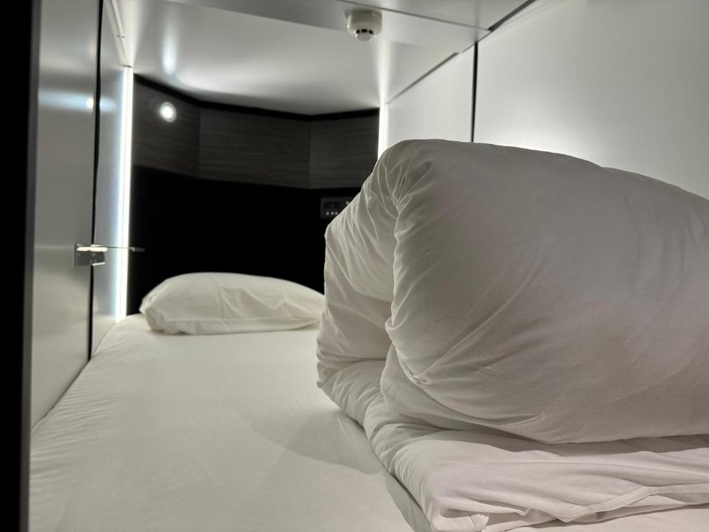Postel nebo postele na pokoji v ubytování Capsule Hotel Suzumoriya