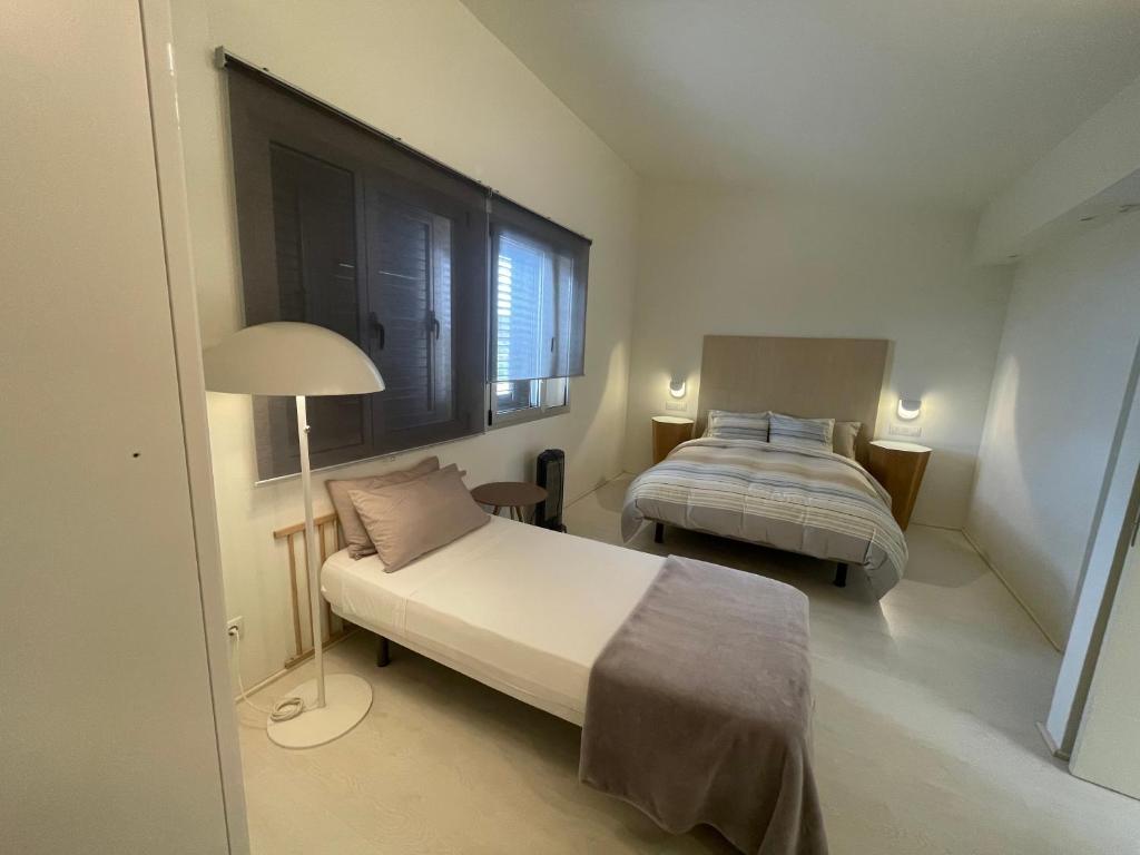 a bedroom with two beds and a lamp in it at Villa con piscina privada Palmeras Home in Las Palmas de Gran Canaria