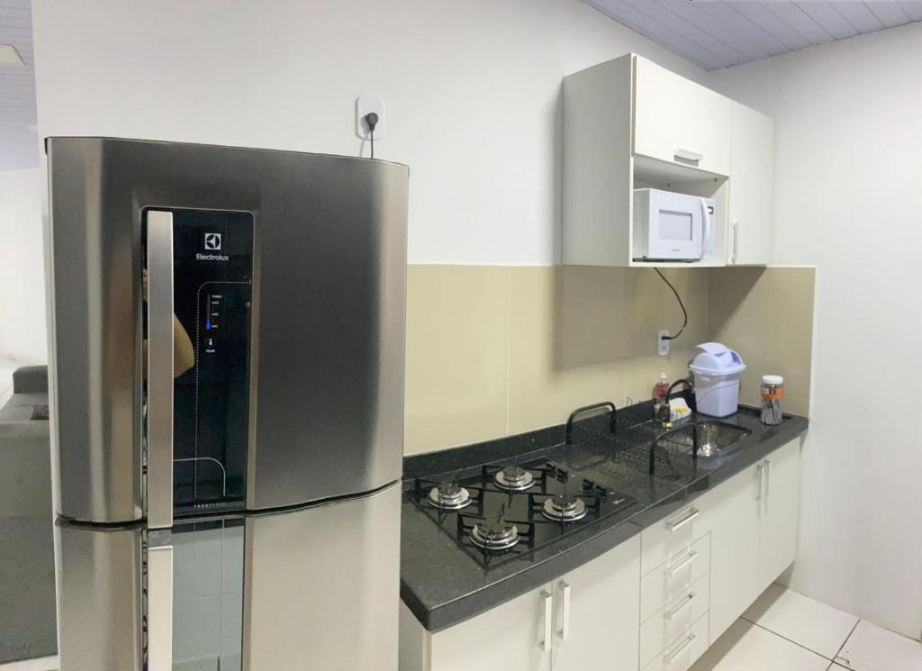 a kitchen with a stainless steel refrigerator and a stove at Apartamento grande para família ou amigos in Boa Vista