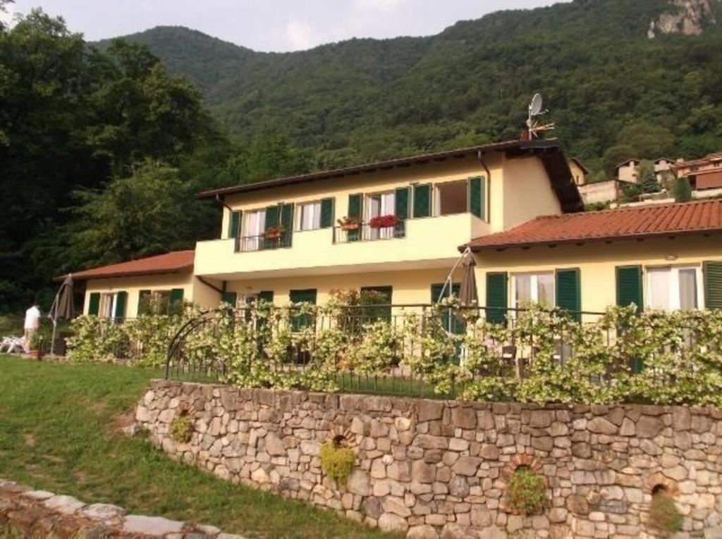 ein Haus auf einem Hügel mit einer Steinmauer in der Unterkunft Ferienhaus in Onno mit Grill, Terrasse und Garten in Onno