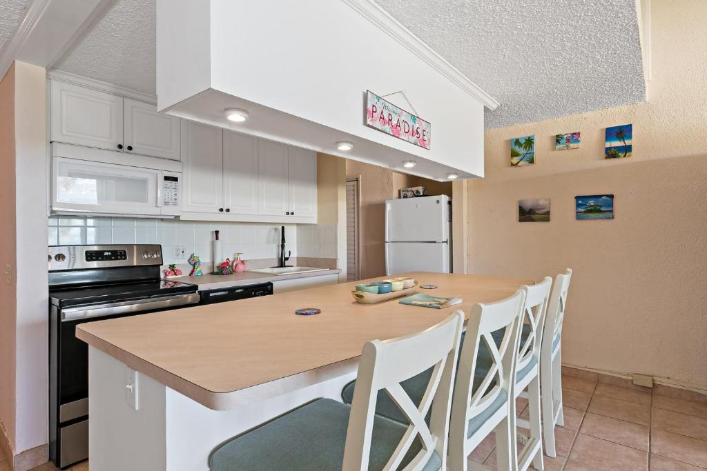 a kitchen with a wooden table and white cabinets at Another Beautiful Day In Paradise in Christiansted
