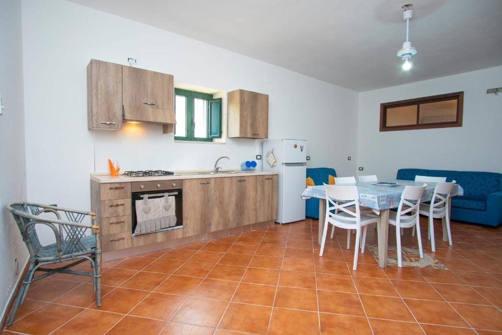 La Dolce Vita في كاميروتا: مطبخ وغرفة طعام مع طاولة وكراسي