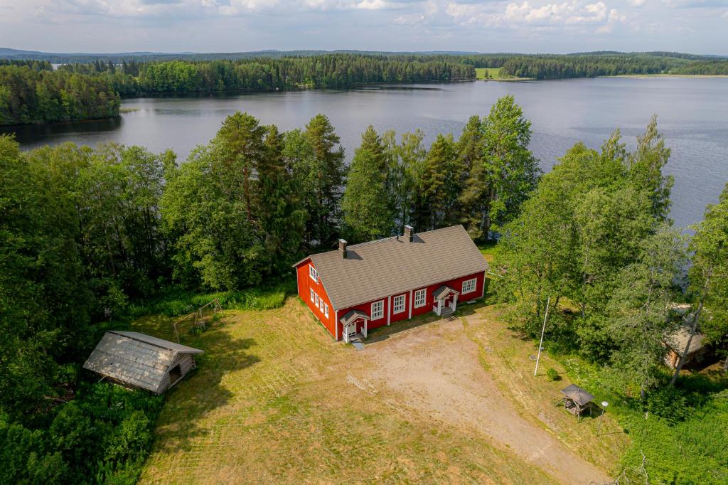 an aerial view of a red barn next to a lake at Ahoniemi - Kellankoski in Rossi