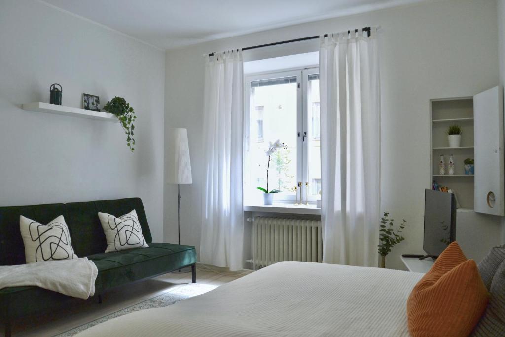 uma sala de estar com um sofá verde e uma janela em Modern and Bright Studio with Top Location em Helsinque