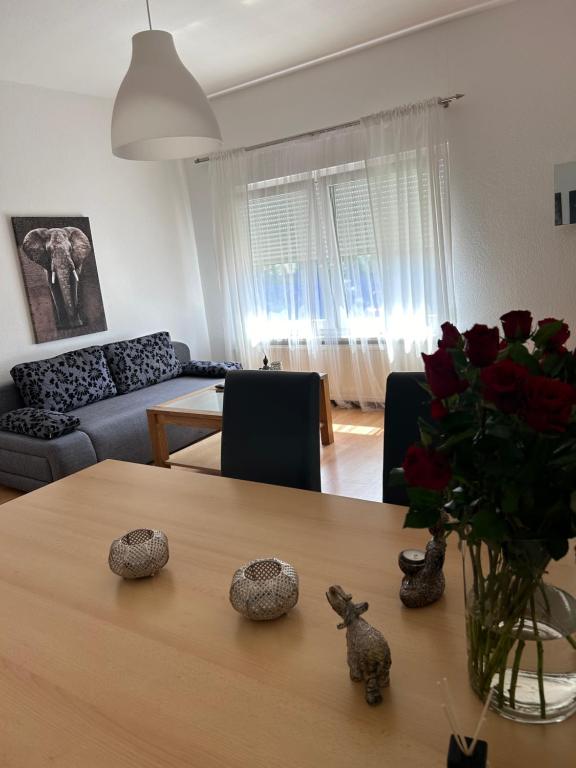 a living room with a table with a vase of roses at Lidia Apartment in Celle