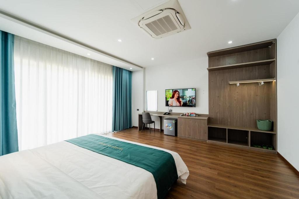 a bedroom with a bed and a television in it at Trường An Hotel in Hoàng Ngà