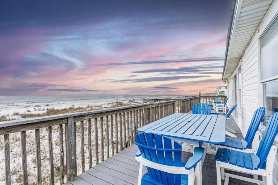 a table and chairs on a deck with the beach at Klitzke House in Gulf Shores