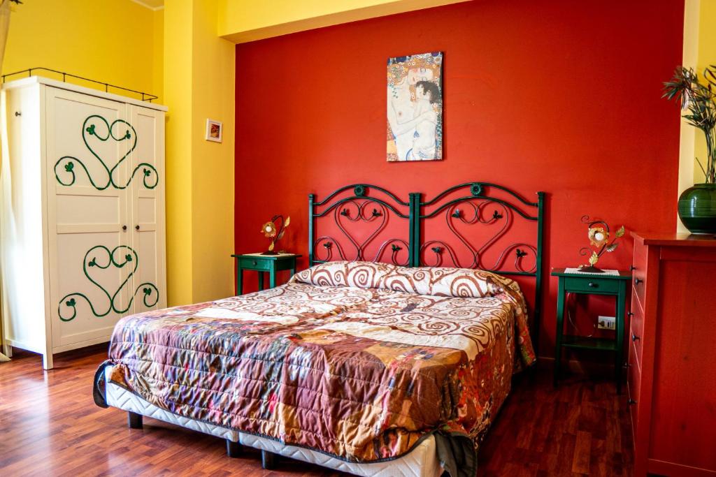 una camera con un letto con una parete arancione di Domus Musia a Milazzo