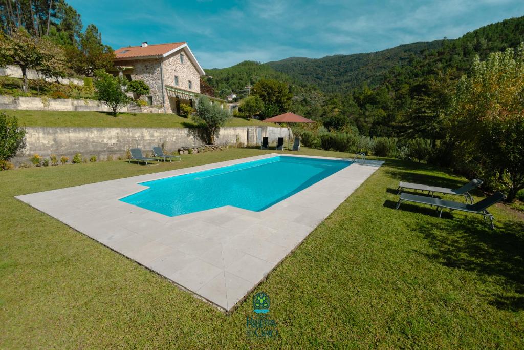 una imagen de una piscina en un patio en Casa da Ribeira do Círio en Seia