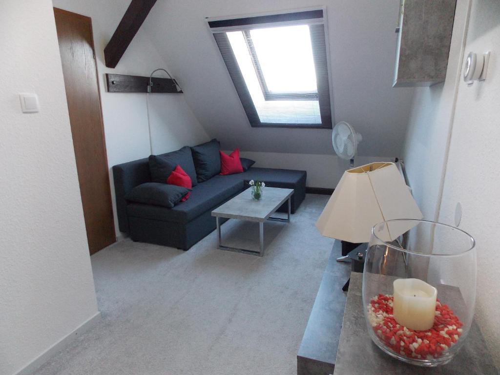 un soggiorno con divano blu e finestra di Ferienwohnung Mohnblume - a44686 a Gerswalde