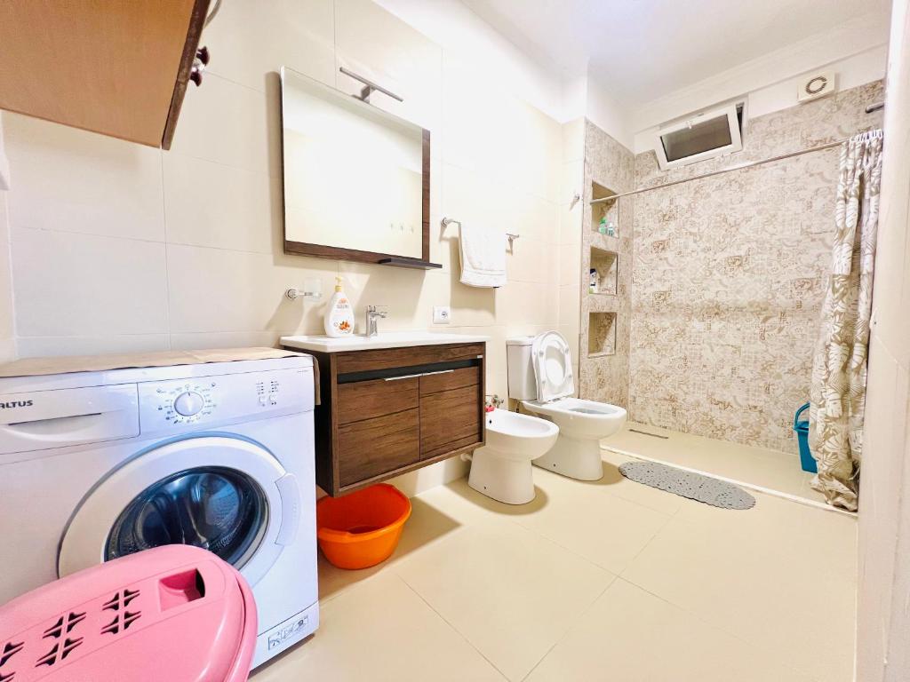 ein Badezimmer mit einer Waschmaschine und einem WC in der Unterkunft N&E Apartment in Durres in Durrës