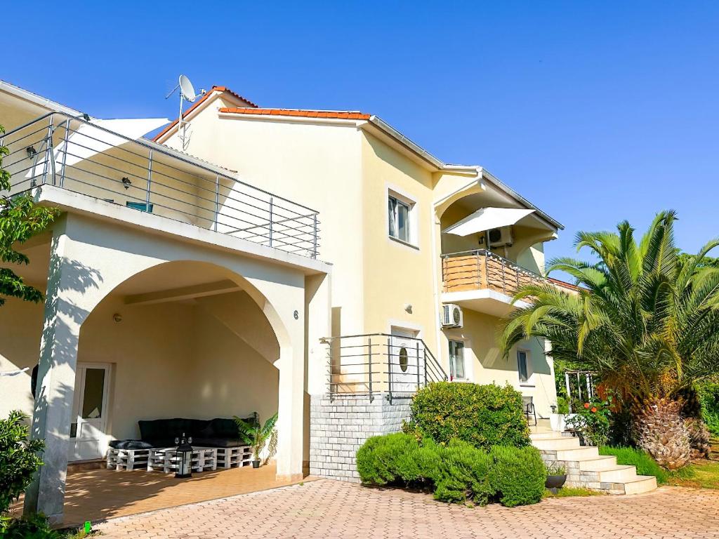 una grande casa con balcone e palma di Sunside Apartments a Pola (Pula)