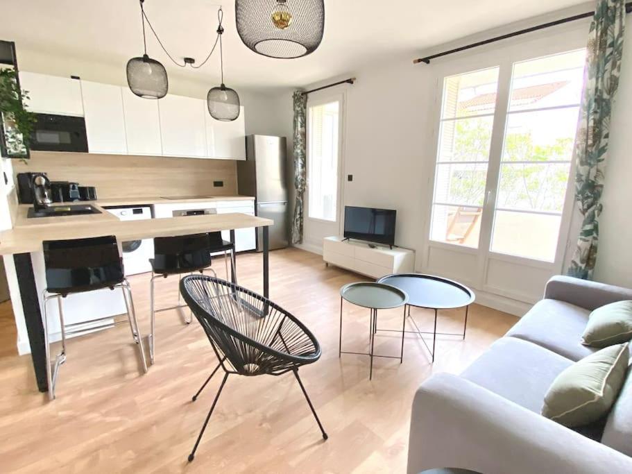 un salon avec un canapé, une table et des chaises dans l'établissement Les Oliviers T2 Ajaccio centre, à Ajaccio