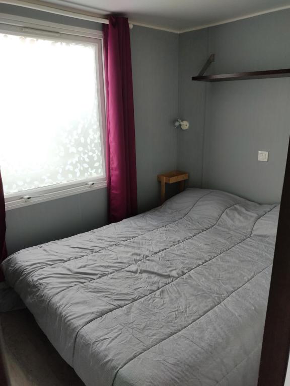 a bedroom with a large bed with a window at Camping du phare d opale p48 in Le Portel