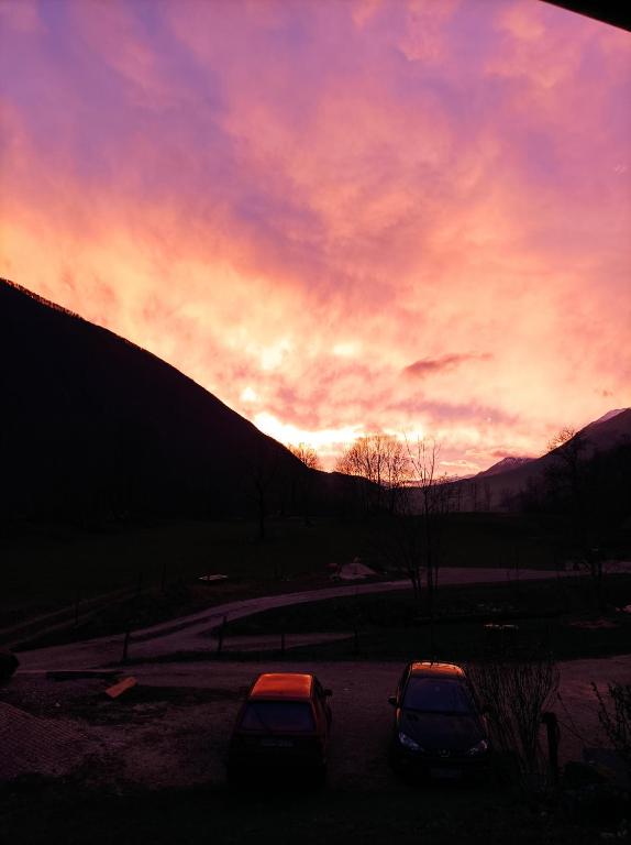 two cars parked in a parking lot with a sunset at Sončni zahod in Kobarid