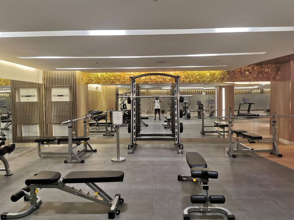 a gym with several treadmills and weights at Moa shore 3 residence in Manila