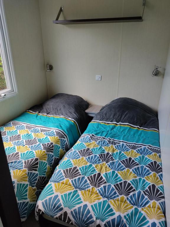 two beds sitting next to each other in a room at Camping du phare d opale p48 in Le Portel