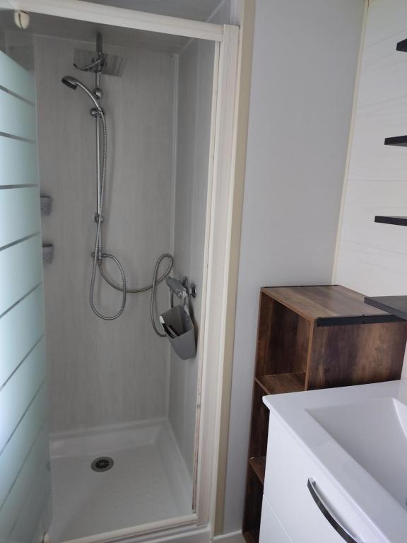 a shower stall in a bathroom with a sink at Camping du phare d opale p48 in Le Portel