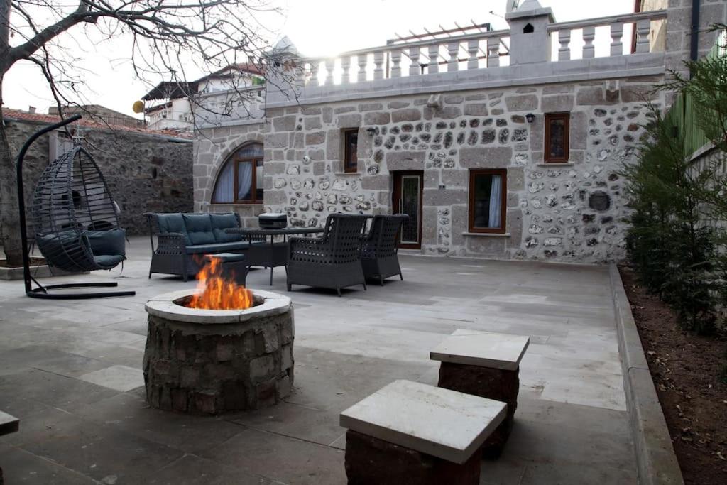 a patio with a fire pit in front of a stone building at Burhan bey konagı in Aksaray