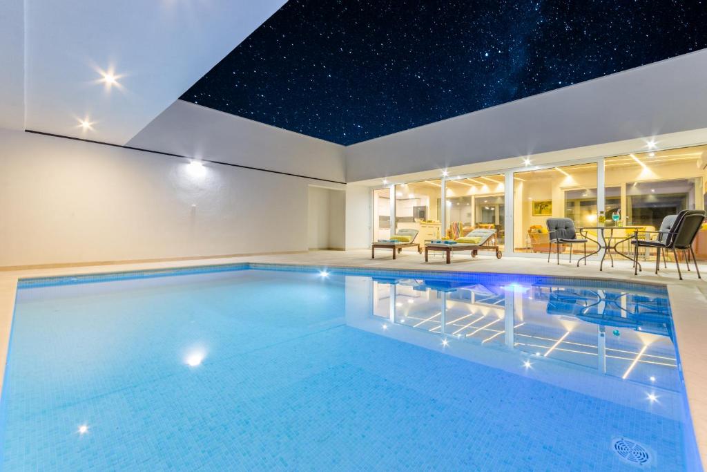 a swimming pool in a house with a star ceiling at Smart Villa in Nerežišće