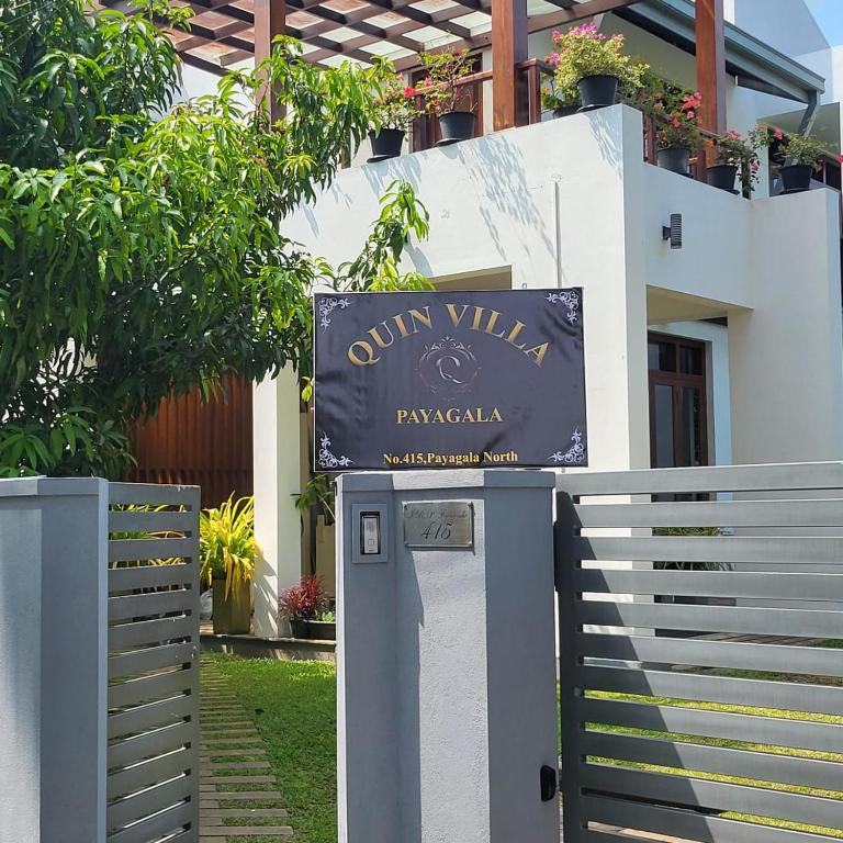 een bord voor een gebouw met een hek bij Quin Villa in Katukurunda-Kalutara