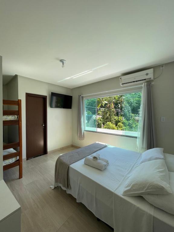 um quarto com uma cama grande e uma janela em Hospedaje MorroSP em Morro de São Paulo