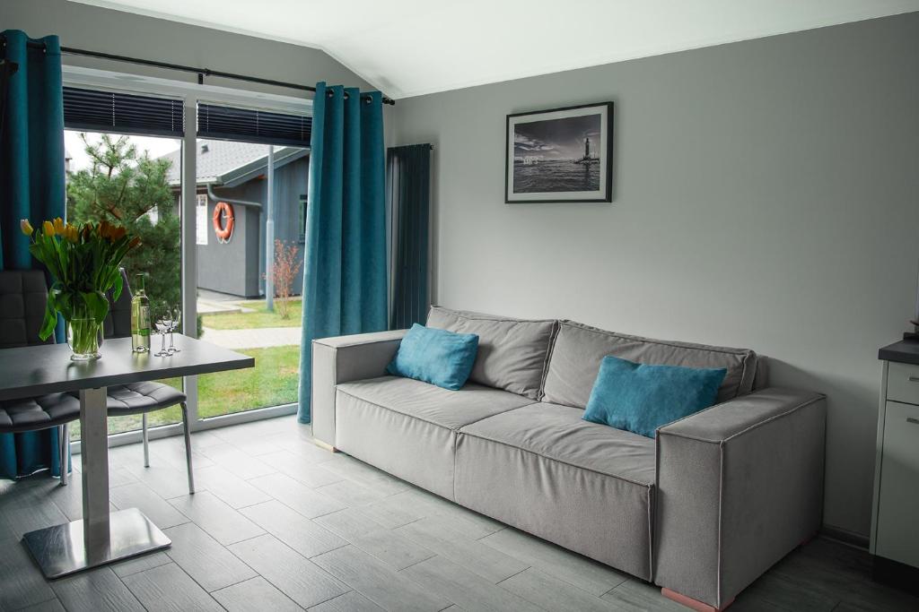 a living room with a couch and a table with blue pillows at Jastrzębia Port in Jastrzębia Góra