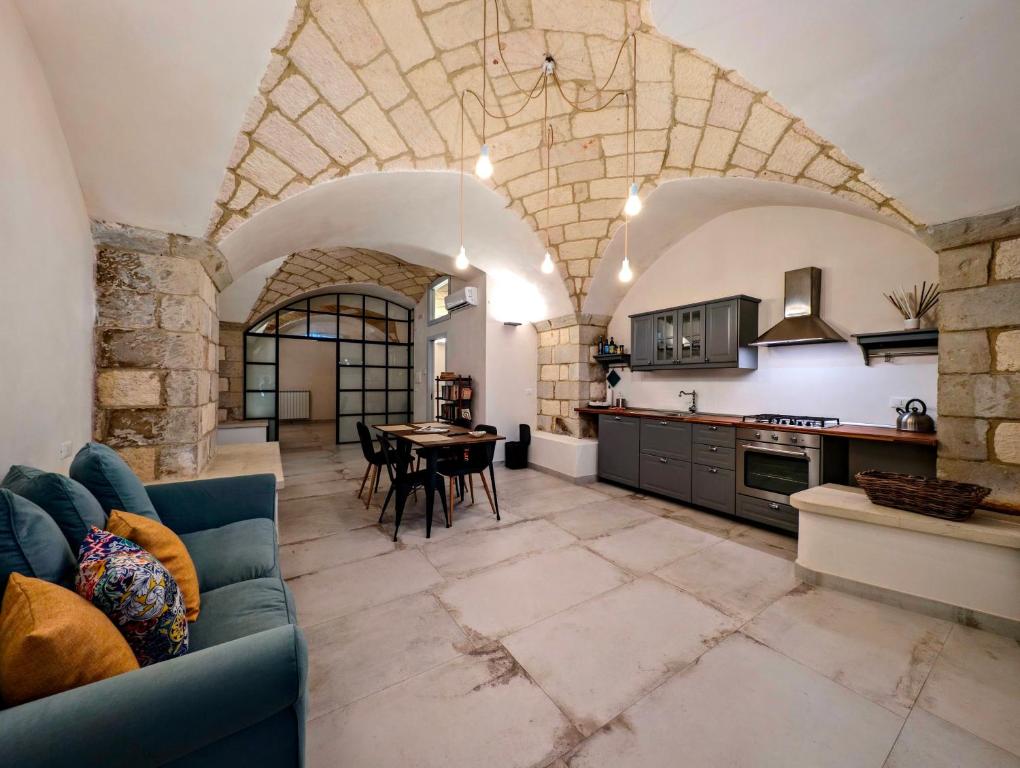 cocina grande con sofá azul y mesa en Oikia Vacanze Giuggianello Le Bey, en Giuggianello