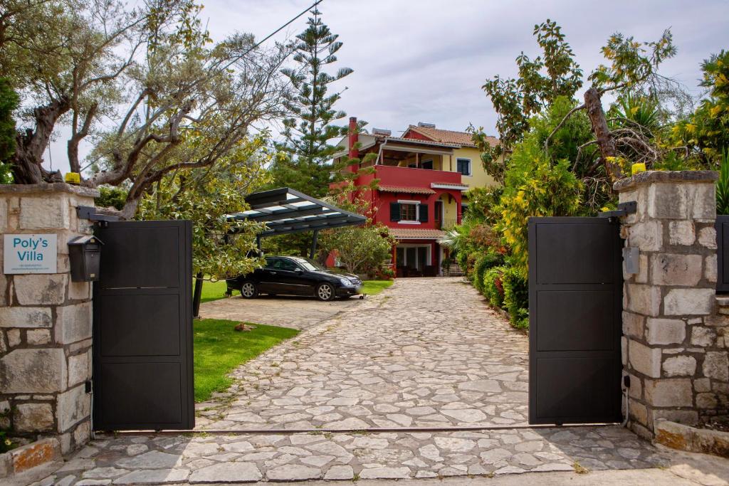 un cancello per un vialetto con una casa sullo sfondo di Poly's Villa Lefkada a Città di Lefkada