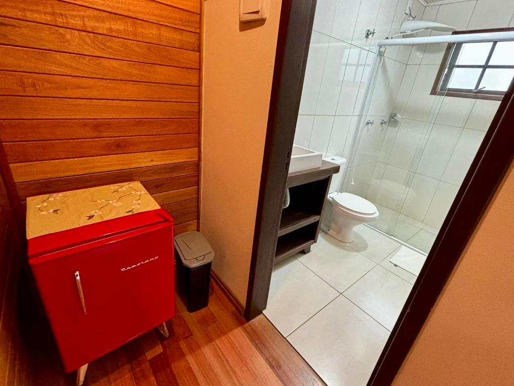 a small bathroom with a toilet and a shower at Namastê - Hospedaria de Altitude in Urubici