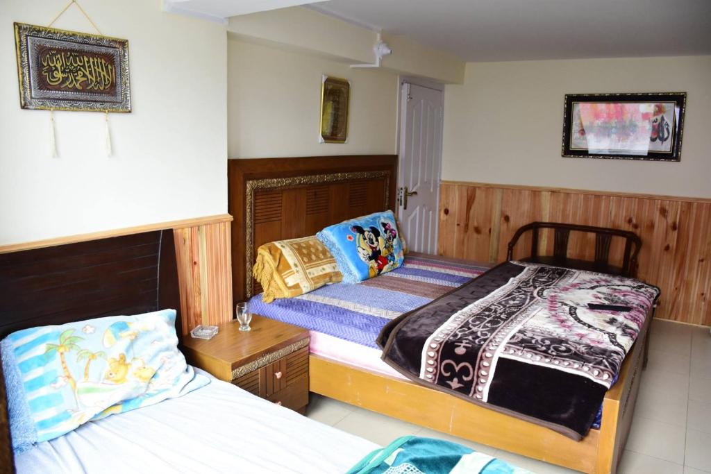 1 dormitorio con 2 camas, mesita de noche y sidx sidx sidx sidx sidx en Quality Inn Hotel en Murree
