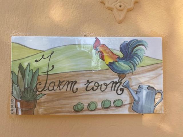 Un dipinto di un pollo su un cartello su un muro di La Fattoria di Valentina a Pomarance