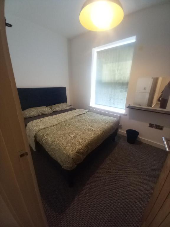 een slaapkamer met 2 bedden en een raam bij Kendras home in Manchester